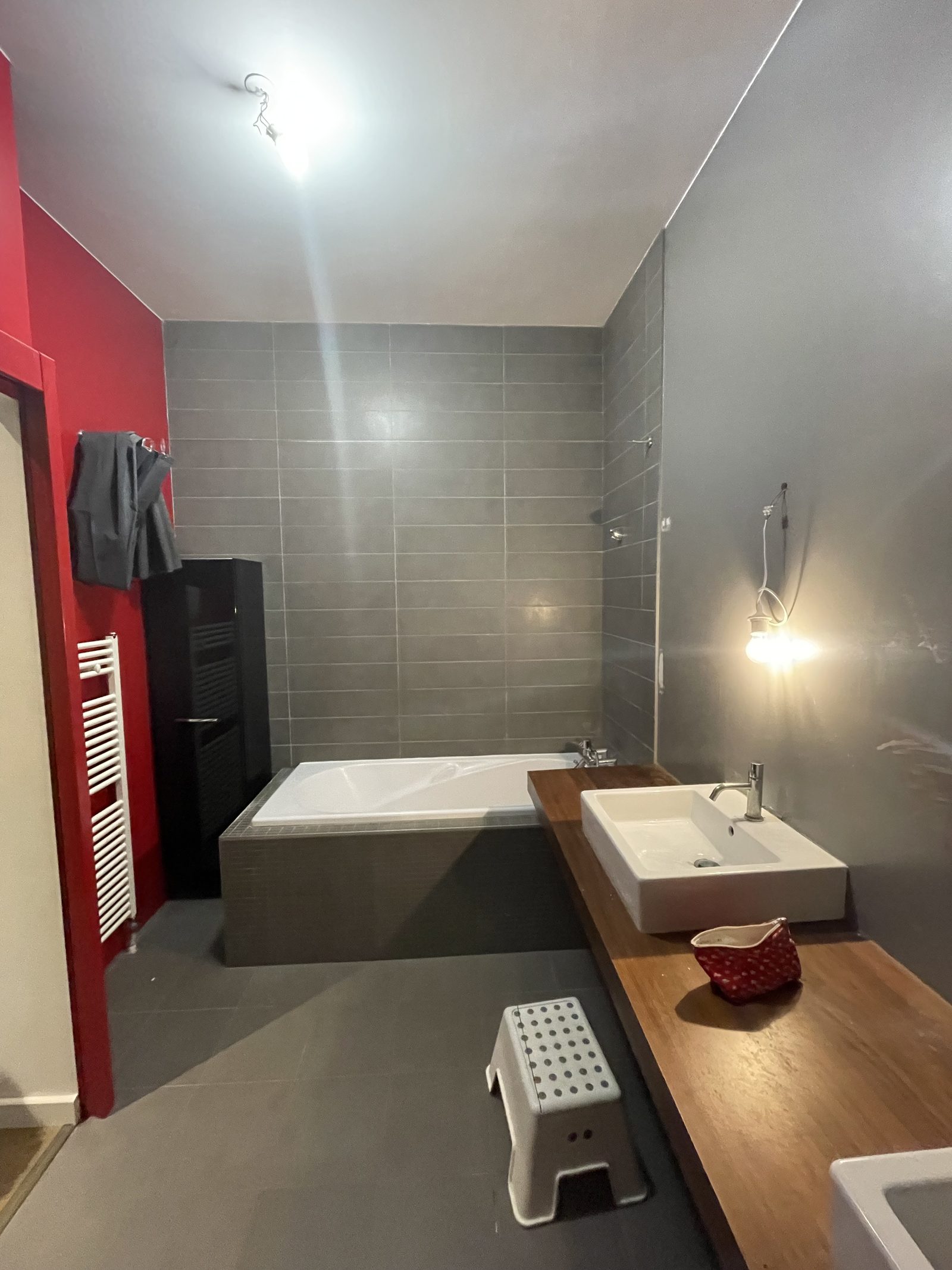 Avant travaux : la salle de bains dans son jus, carrelage gris et mur bordeaux, à Villeurbanne