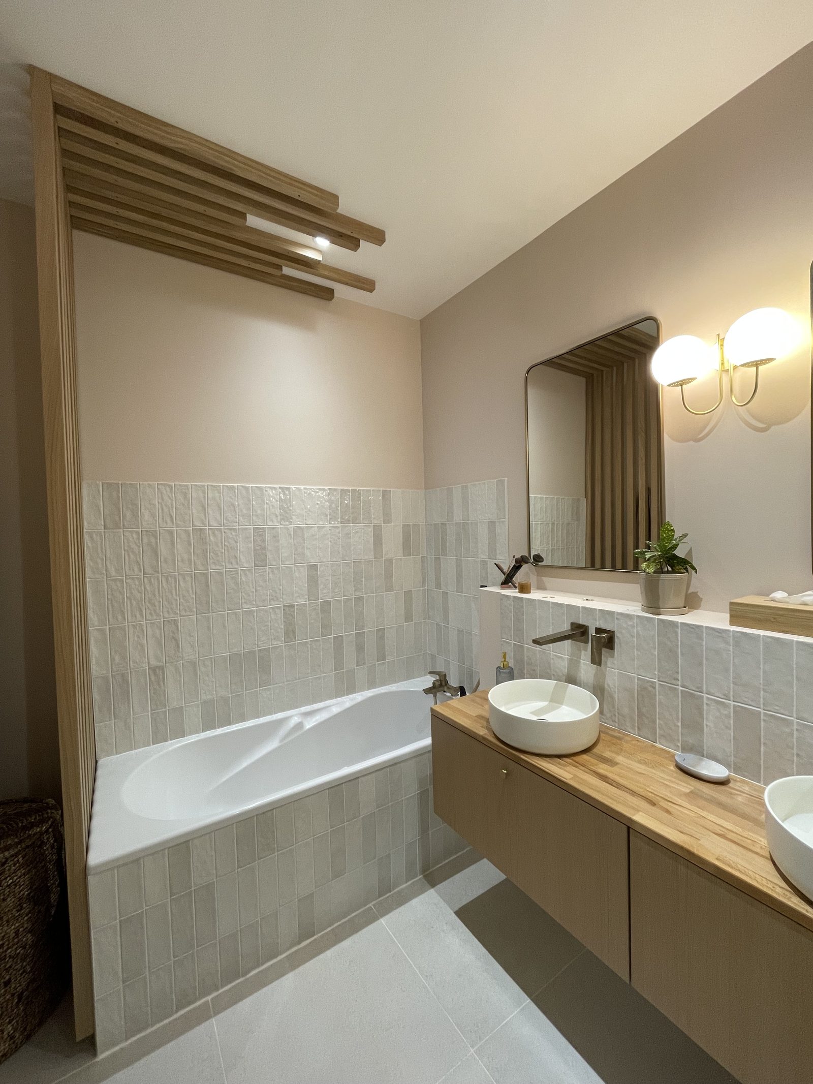 Baignoire habillée de zellige avec tasseaux de bois au plafond et miroir en laiton, salle de bains à Villeurbanne