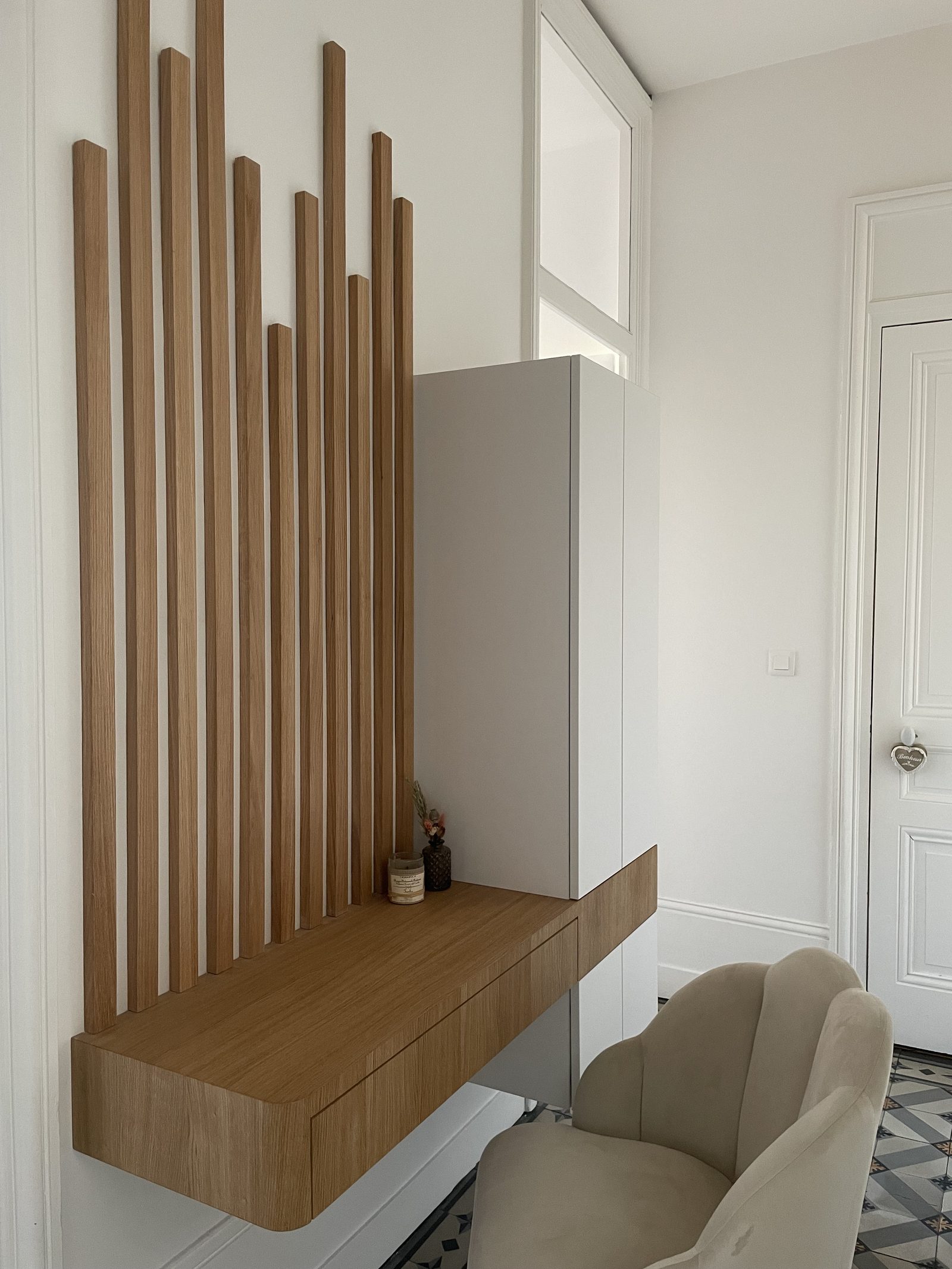 Bureau flottant en chêne sur-mesure avec tiroir et tasseaux de bois verticaux, entrée à Lyon