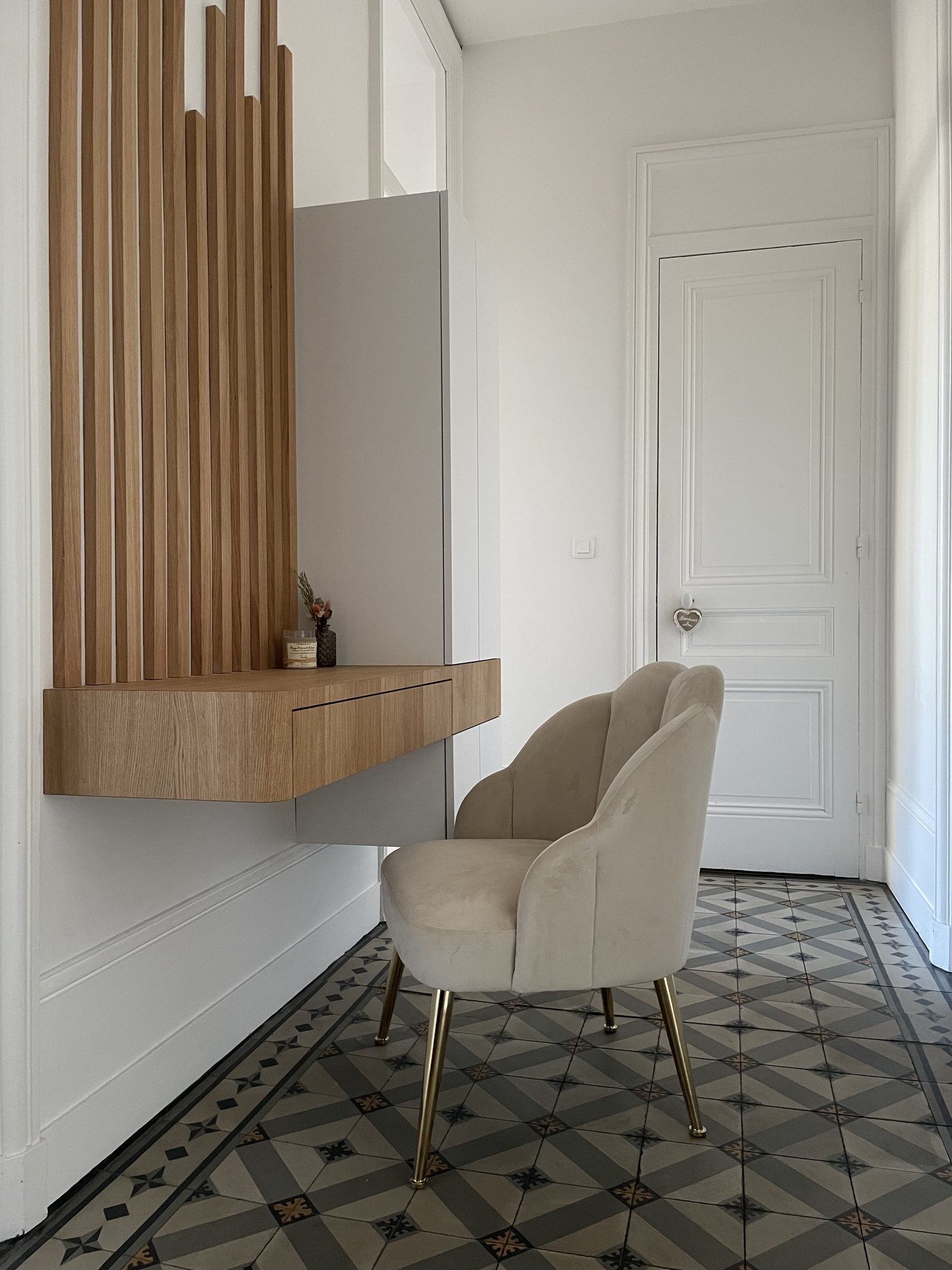 Le bureau sur-mesure prenant l'allure d'une console, avec fauteuil beige, dans l'entrée à Lyon