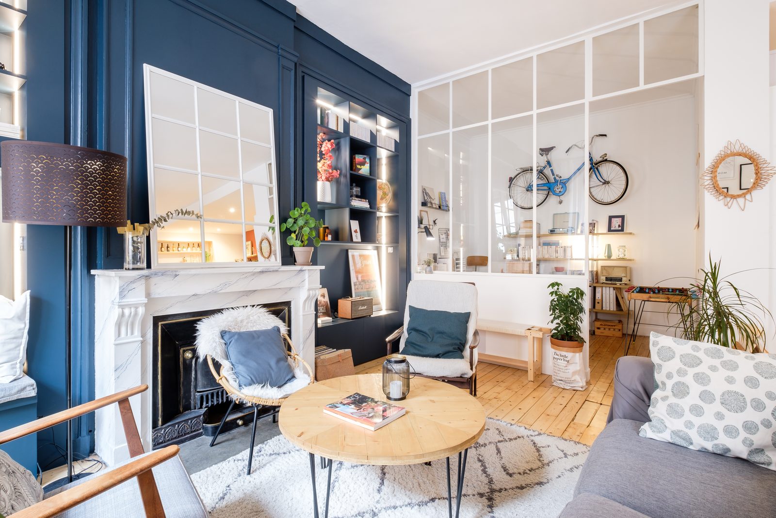 Pièce de vie lumineuse avec cheminée, plantes et mobilier scandinave