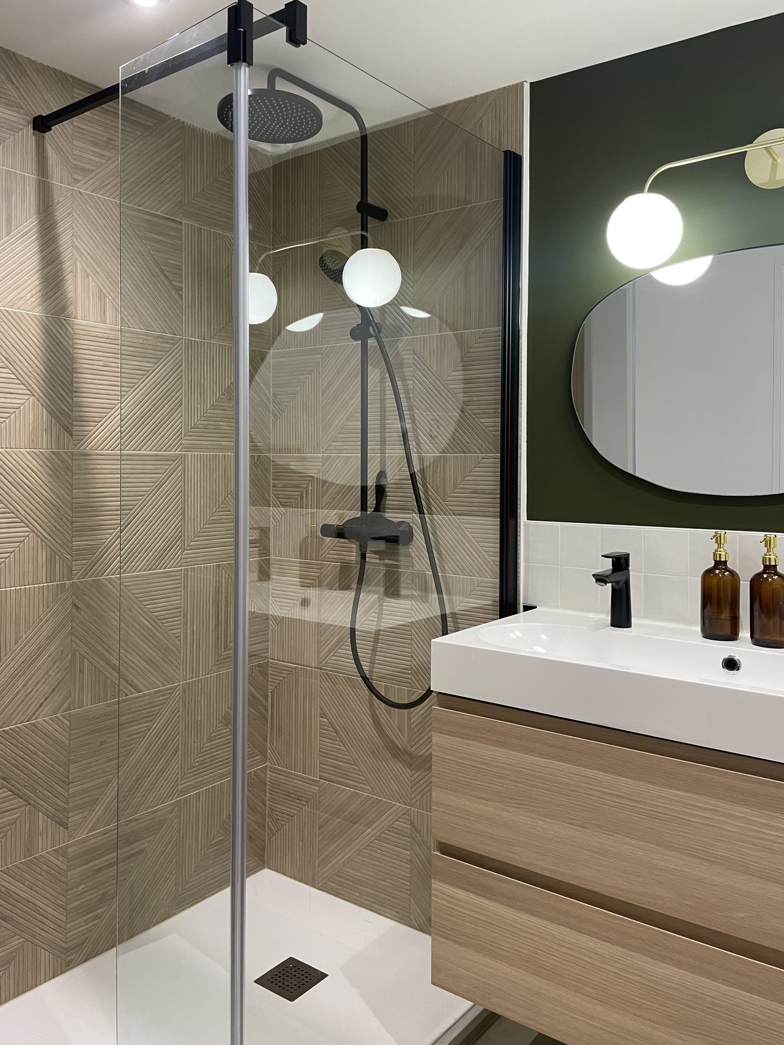 Douche à l'italienne à cadre noir devant un carrelage imitation bois au motif graphique, salle de bains rénovée à Lyon