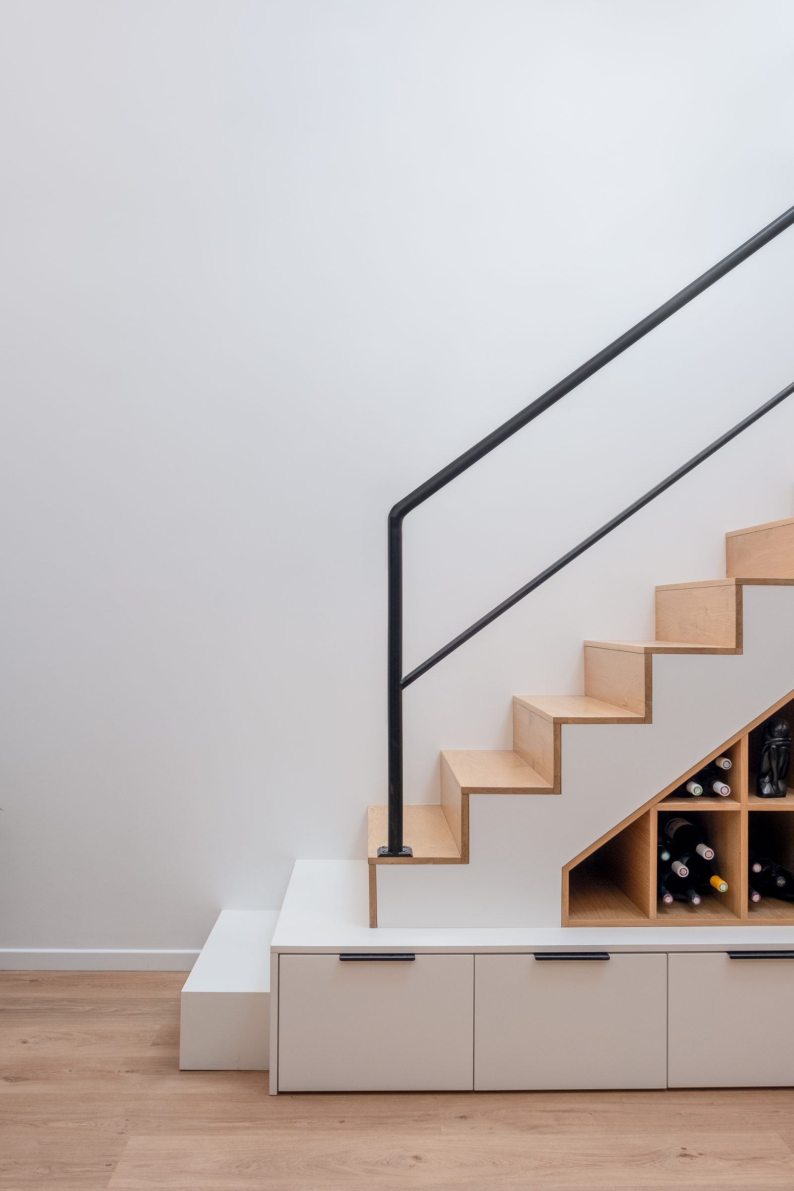Banquette nichée et rangements intégrés sous un escalier sur-mesure à Villeurbanne