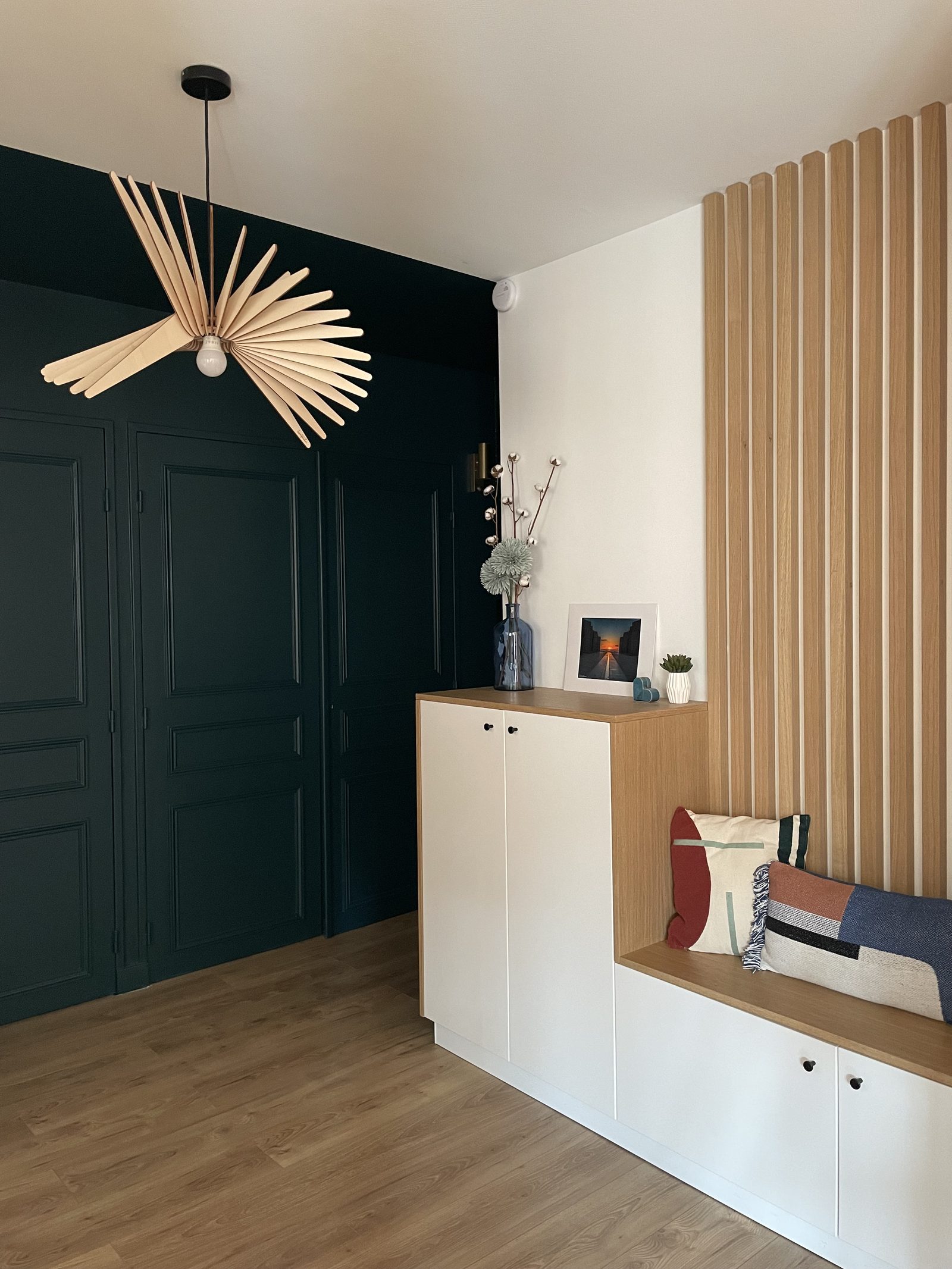 Entrée avec placards vert profond, meuble bas et banquette sur-mesure et mur en tasseaux de bois, appartement à Villefranche