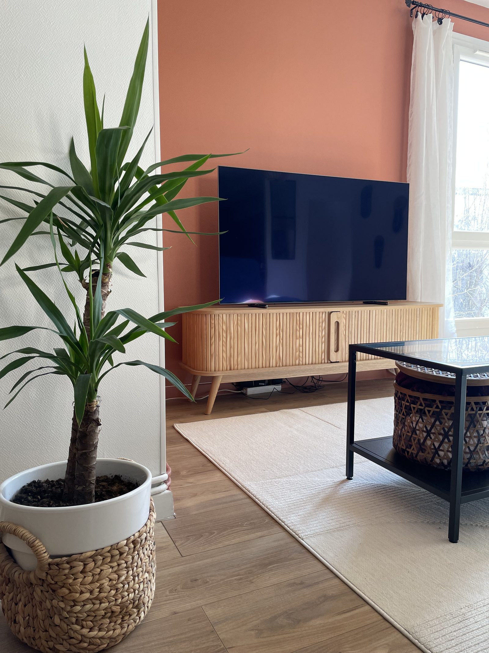 Salle à manger avec table en bois, chaises noires et terracotta et claustra en tasseaux, appartement à Villefranche