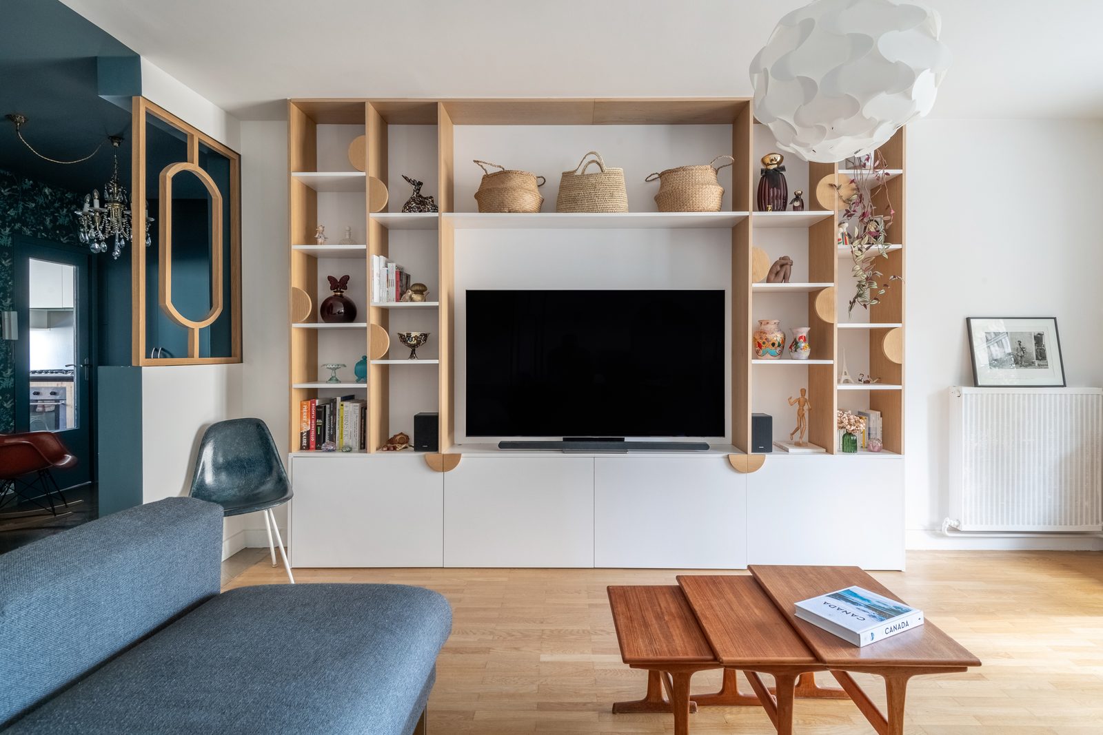 Meuble TV et bibliothèque sur-mesure en chêne et blanc, canapé d'angle bleu, appartement à Lyon 3e
