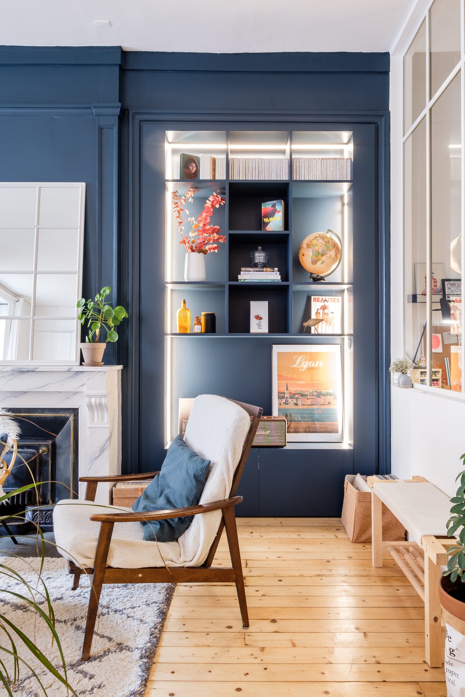 Verrière blanche devant une bibliothèque bleu profond dans un salon à Lyon