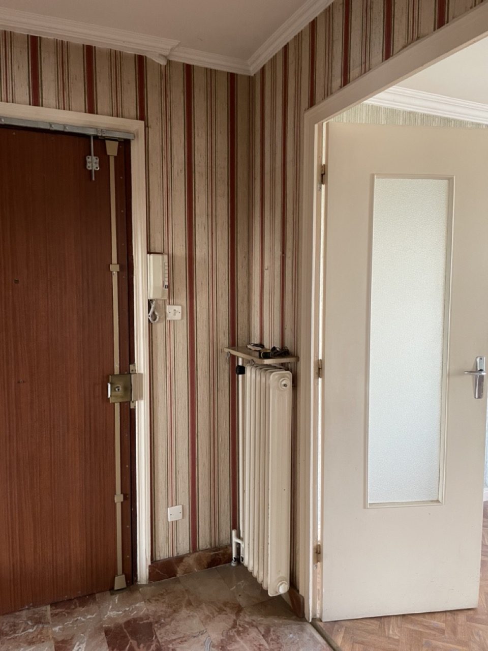 Avant travaux : l'entrée de l'appartement avec l'un des nombreux papiers peints d'origine, à Bron