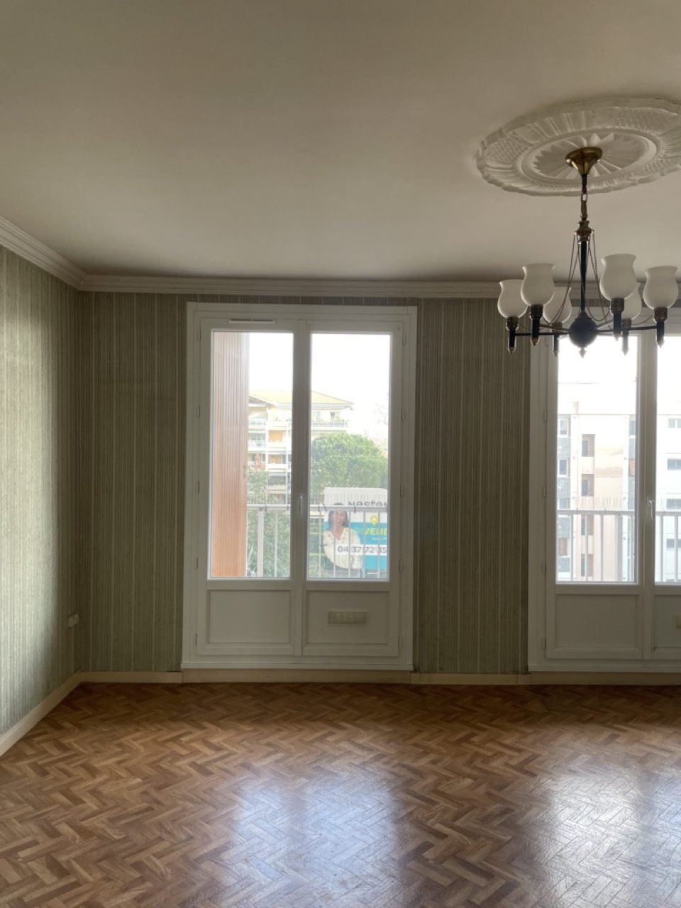 Avant travaux : le séjour dans son jus, papier peint rayé et vieux parquet, appartement à Bron