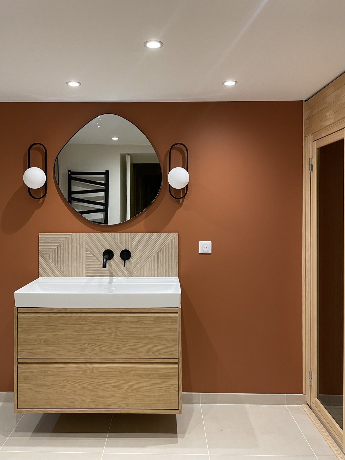 Salle de bain de style rétro avec vasque et miroir rond à Lyon